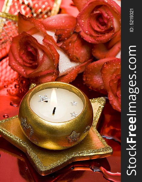 Golden candle with red roses