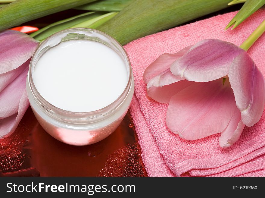 Cream, towel with flowers on red background