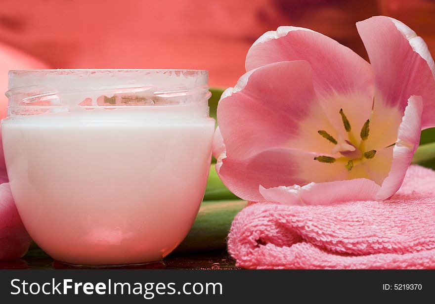 Cream, towel with flowers on red background