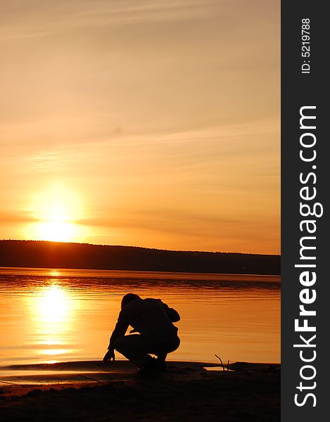 Silhouette of young man on a beach at sunset. Silhouette of young man on a beach at sunset.