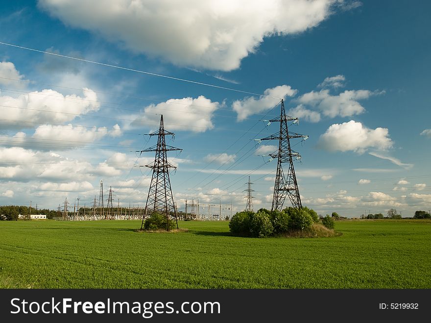 Powerlines in the field under clowdy sky. Powerlines in the field under clowdy sky