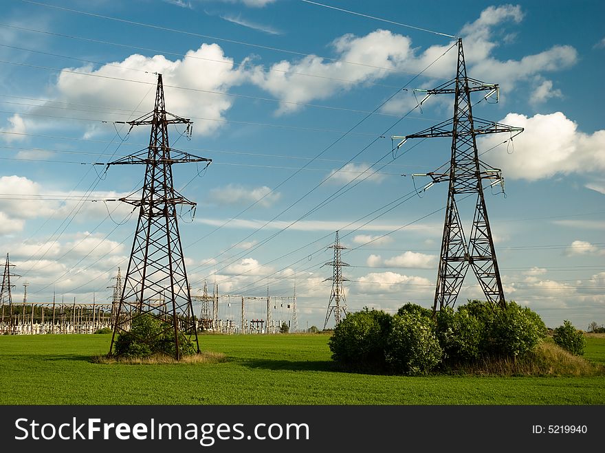 Powerlines in the field under clowdy sky. Powerlines in the field under clowdy sky