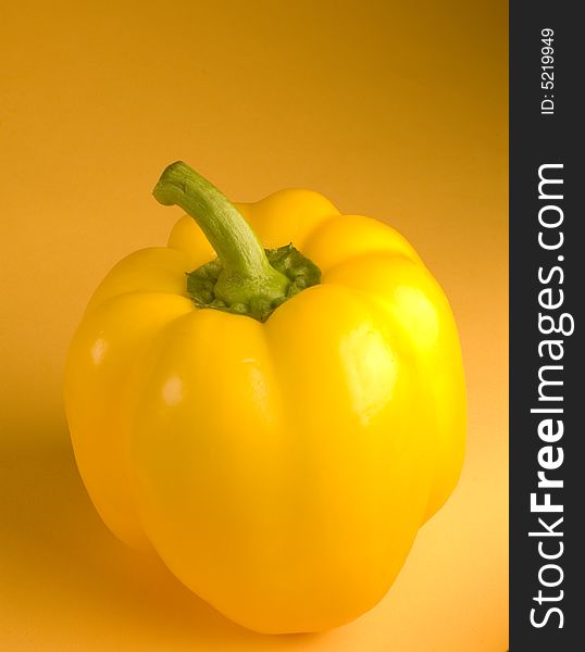 A yellow pepper underneath studio lighting
