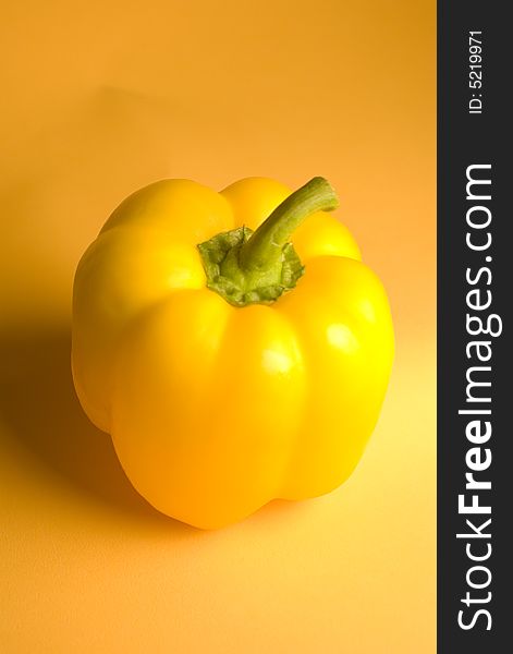 A yellow pepper underneath studio lighting