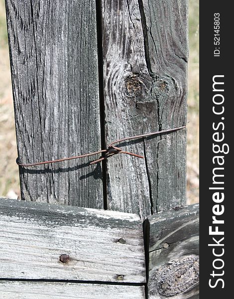 Old weathered wooden country fence with rusty wire and nails. Old weathered wooden country fence with rusty wire and nails.