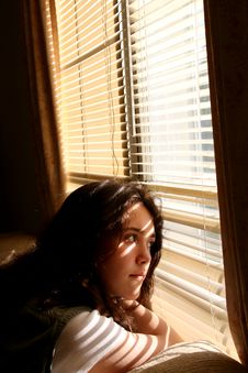 Young Woman Daydreaming Out Window Stock Images