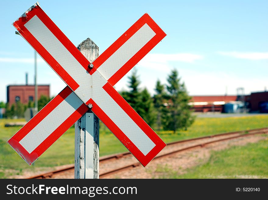 Old railroad crossing stop sign in a rural scene with shallow focus