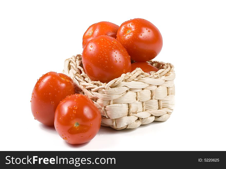Fresh tomatoes  with waterdrops in a basket isolated on a white background. Fresh tomatoes  with waterdrops in a basket isolated on a white background.
