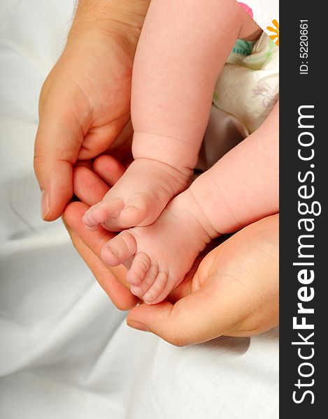 Feet of a young baby in dads hand. Feet of a young baby in dads hand