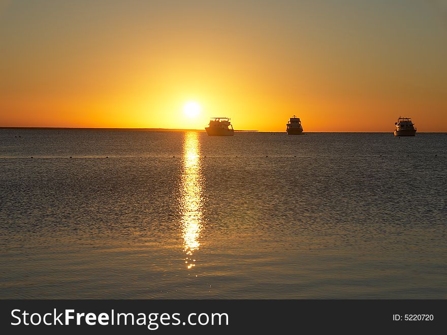 Boats silhouette and golden sunrise over the ocean. Boats silhouette and golden sunrise over the ocean