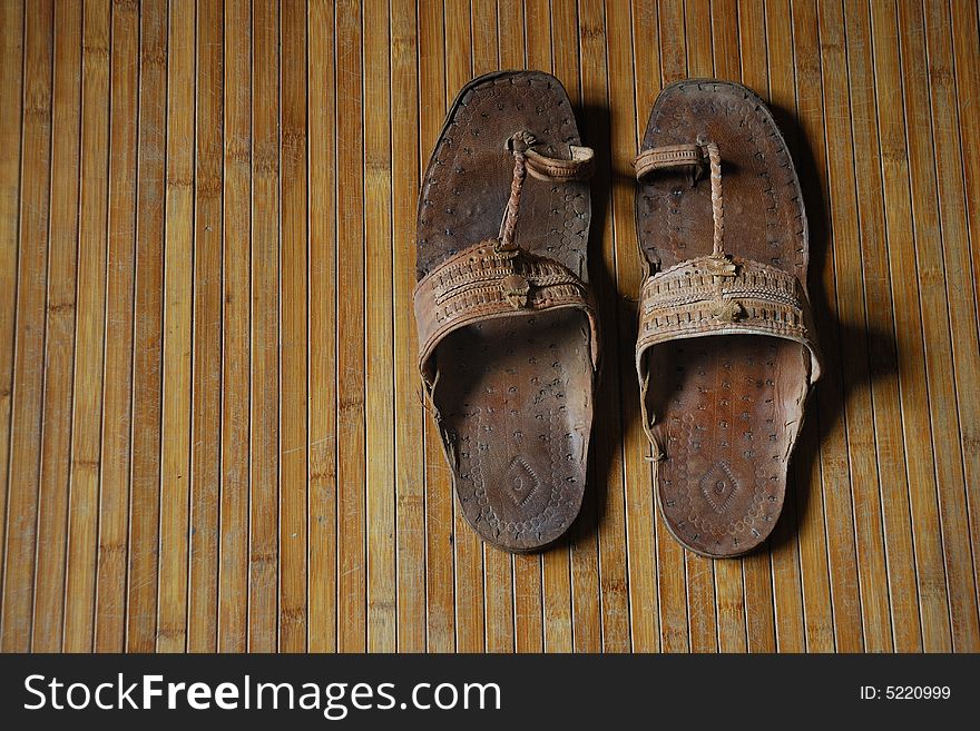 Worn sandal on bamboo mat