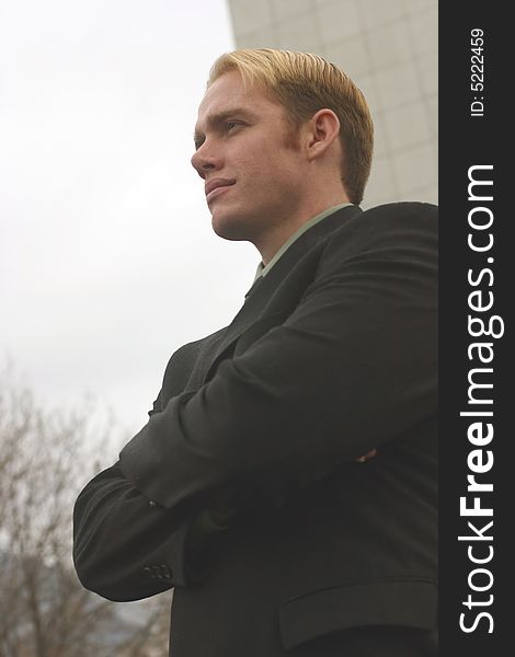 Young businessman wearing suit standing outside office building. Young businessman wearing suit standing outside office building