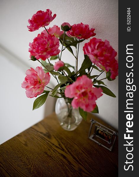Pink flowers in a vase on a table inside a home