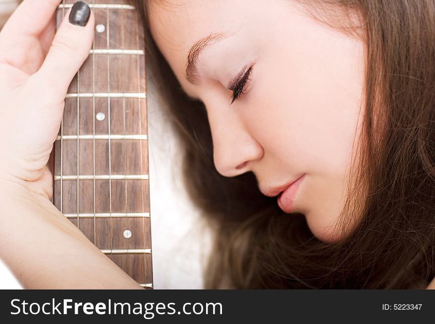 Lovely brunette with an electric guitar over white. Lovely brunette with an electric guitar over white