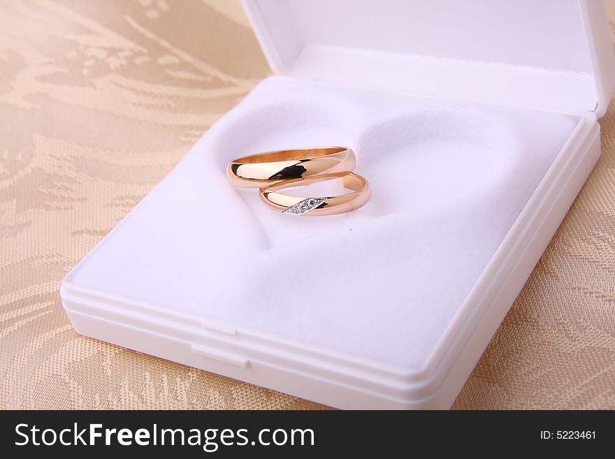 Wedding rings in jewelry box with heart shape