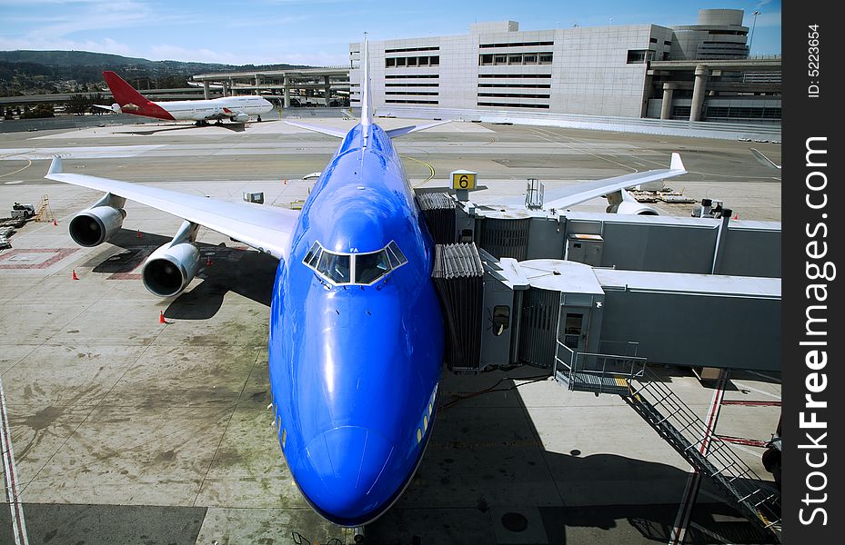 Blue airplane being refuelled on a runway. Blue airplane being refuelled on a runway