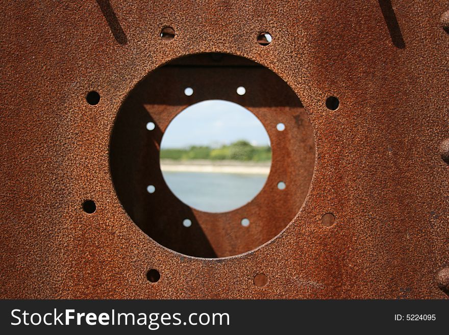 Looking through a rusty porthole with the center with a shallow DOF