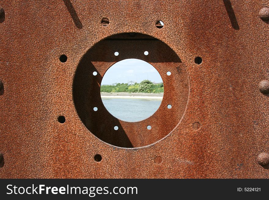 Looking through a rusty porthole with the center with a Sharp DOF. Looking through a rusty porthole with the center with a Sharp DOF