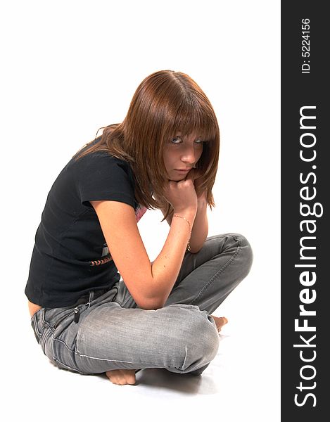 Girl in a black vest sits on a floor