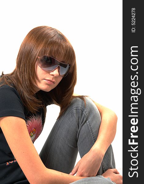 The girl in a black vest sits on a floor - a white background