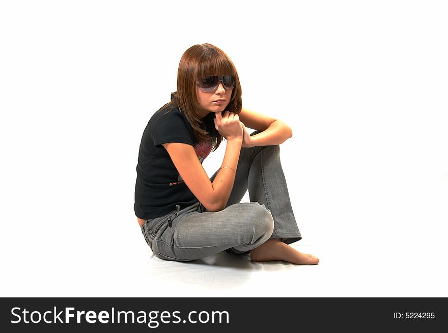 The girl in a black vest sits on a floor - a white background