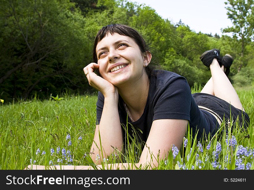 Happy young girl laying in grass