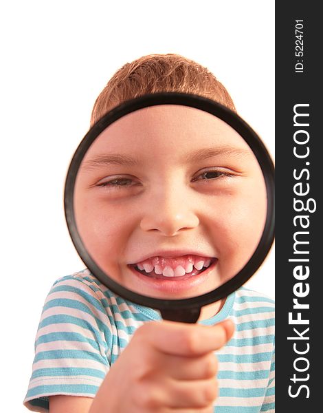 Smiling child looks through magnifier on white