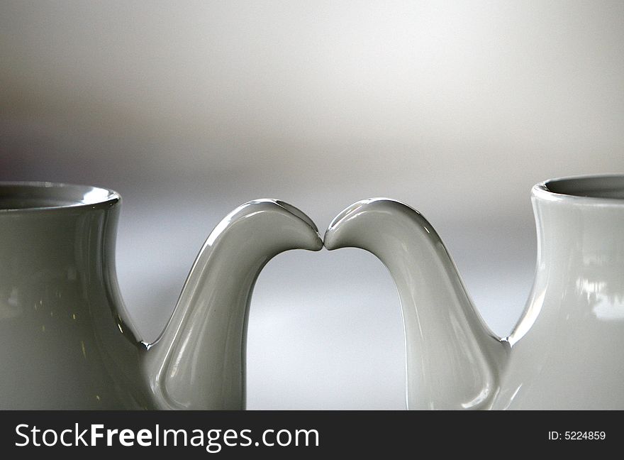 Two porcelain white teapots in a simple background. Two porcelain white teapots in a simple background