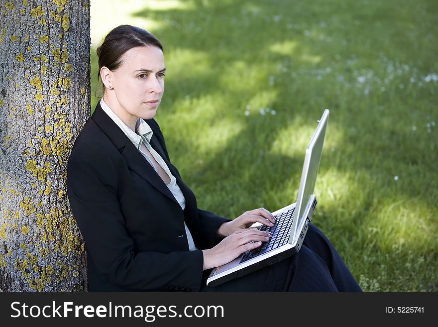 A young employee working outdoors with a laptop