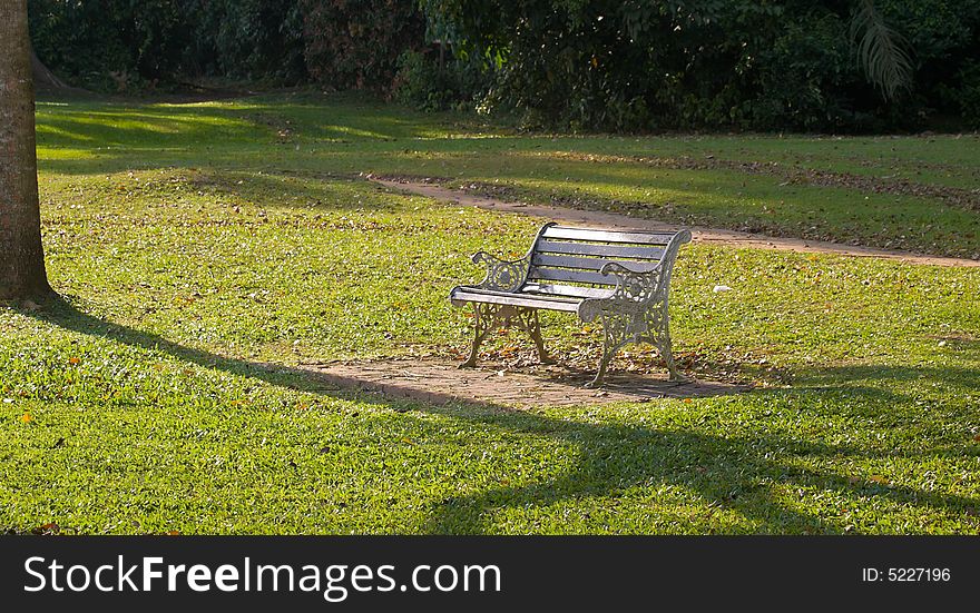 Park bench illuminated by the setting sun in the late afternoon