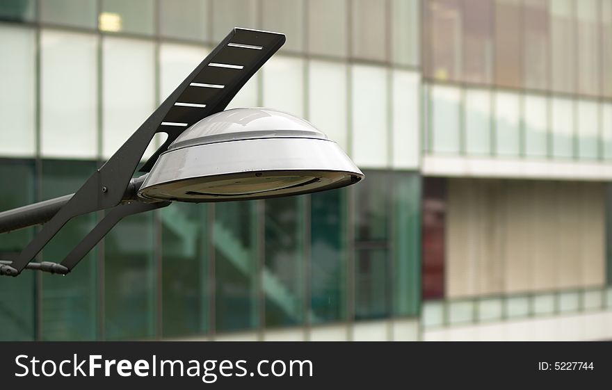 Modern styled street lamp against the facade of a modern office building. Modern styled street lamp against the facade of a modern office building
