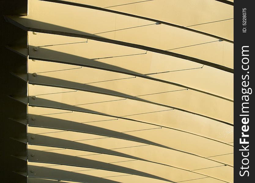 Series of metal arches casting shadows on themselves in the morning light