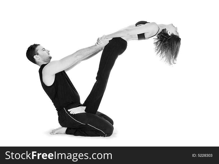 Male and female gymnasts practicing a complex double yoga pose. Male and female gymnasts practicing a complex double yoga pose.