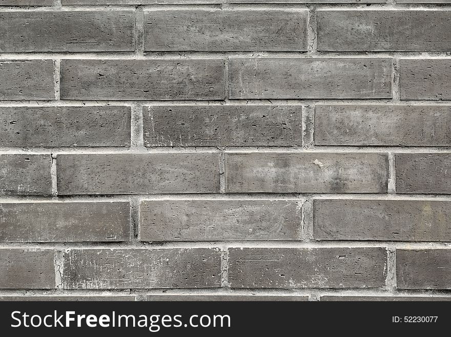 Close-up of the small black bricks in the wall of a building,a good the background source material.