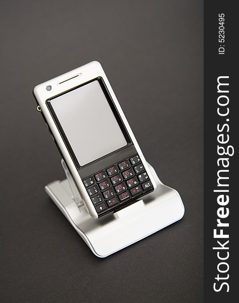 PDA phone in holder on dark background