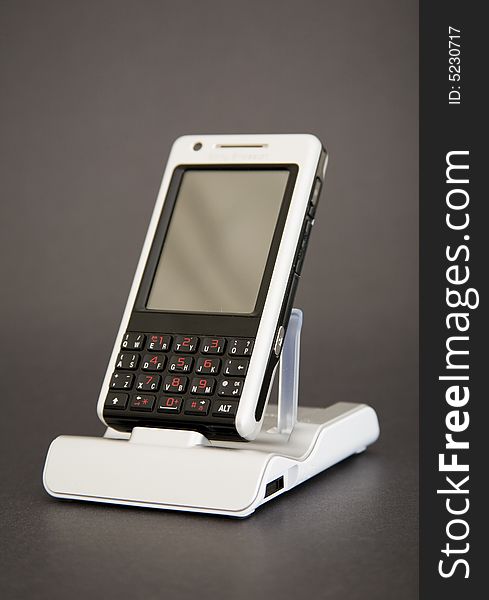 PDA phone in holder on dark background