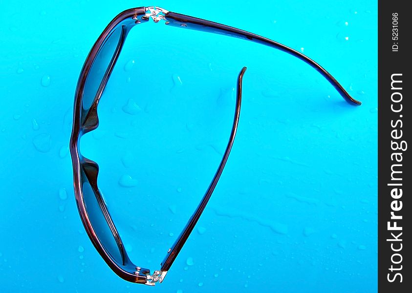 Sun glasses over plastic swimming pool