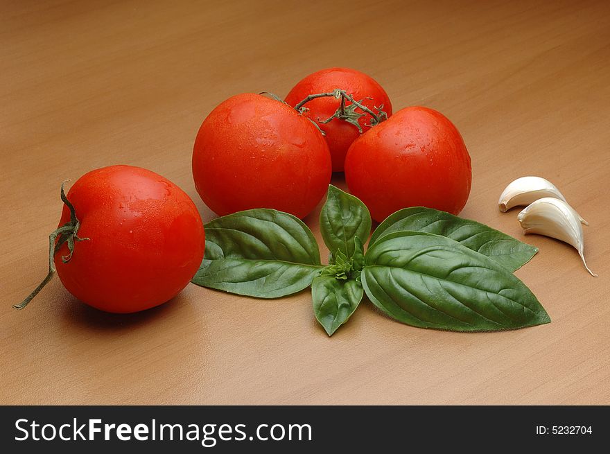 Tomatoes, basilico, and garlic over wooden background. Tomatoes, basilico, and garlic over wooden background