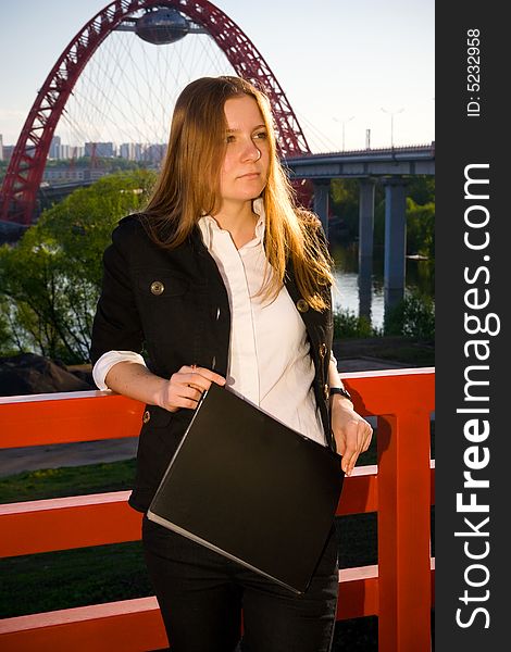 The young businesswoman with a folder on a background of the blue sky