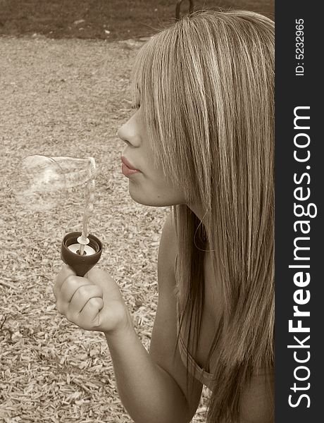 Closeup of a teenage girl blowing bubbles. Selective Colored Photo.