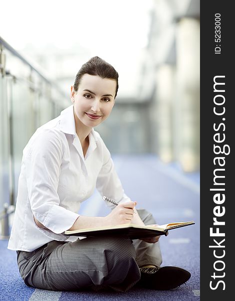 Businesswoman is sitting on the floor with a calendar on hewr lap. Businesswoman is sitting on the floor with a calendar on hewr lap