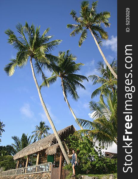 Cloudscape over the famous resort with woman posing in front of a bungalow. Tahiti. French Polynesia. Cloudscape over the famous resort with woman posing in front of a bungalow. Tahiti. French Polynesia