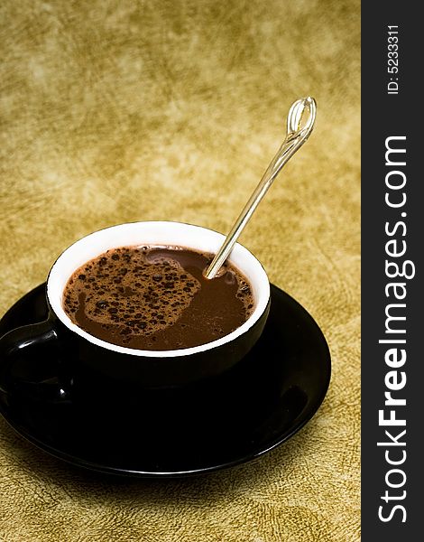 Black cup of coffee with spoon