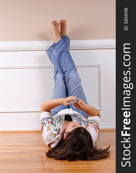 A teenage girl hanging out and listening to music on headphones.