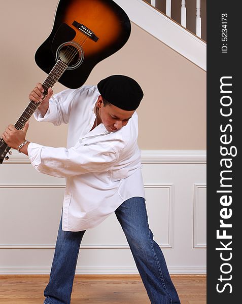 A young man swinging his guitar in frustration. A young man swinging his guitar in frustration.