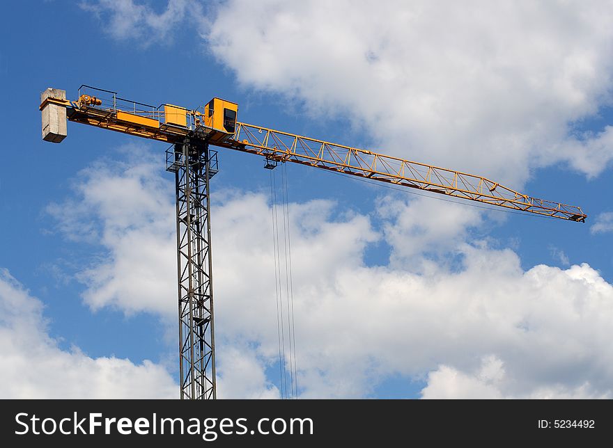 Lifting crane uder blue sky with clouds