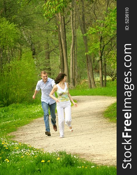 A young happy and smiling couple is playing tag. A young happy and smiling couple is playing tag