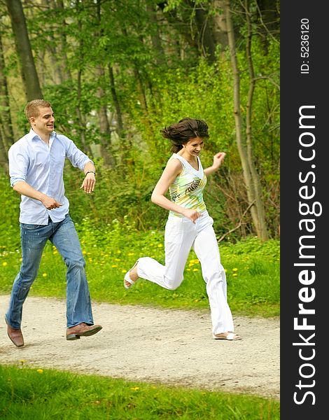 A young happy and smiling couple is playing tag. A young happy and smiling couple is playing tag