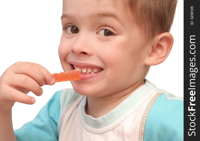 The boy eats fruit candy on a white background