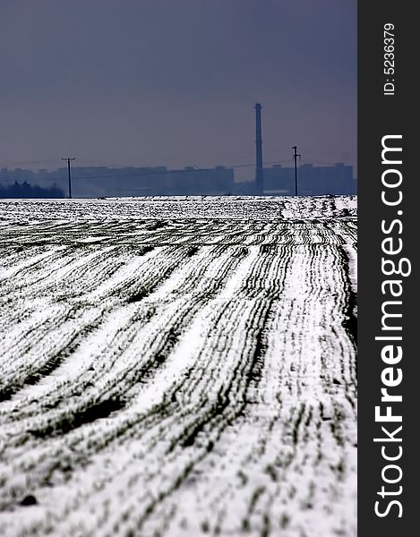 Winter field contrasted with industrial landscape. Winter field contrasted with industrial landscape